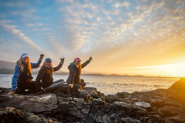 Three guest toasting to the day at sunset