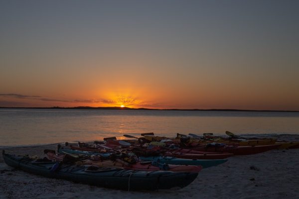 Sunset over a beach of kayaks in the Bahamas