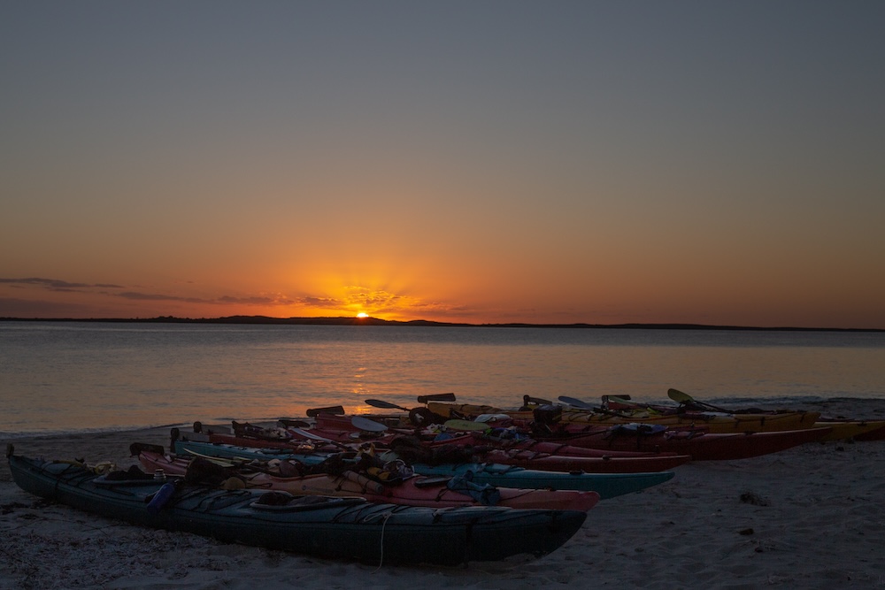 Sunset over a beach of kayaks in the Bahamas